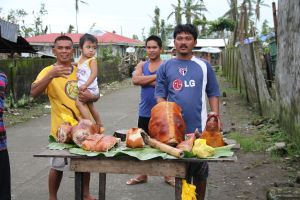 Butchers already back at work in the village streets serving the local delicacy of roast pig!