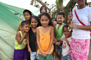 Children outside a roadside UKAID tent on the road to Guiuan, Philippines