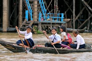 Children paddling back from school in a floating village on Tonle Sap in Cambodia
