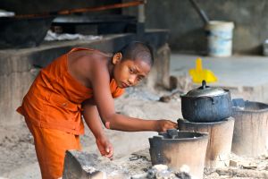 A novice monk gets the cooking started in the countryside outside Siem Reap